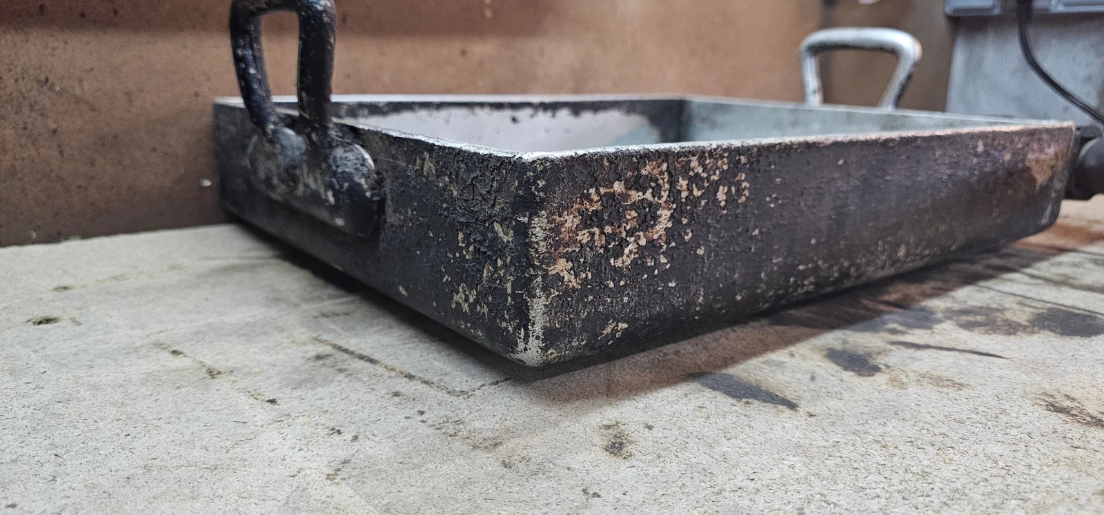Plat en aluminium avant intervention, face extérieure recouverte d’une épaisse graisse cuite