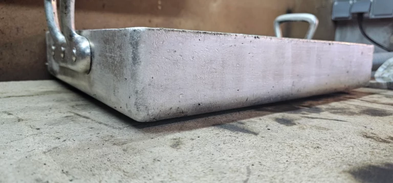 Surface extérieure du plat en aluminium après nettoyage laser, avec les marques du métal visibles.