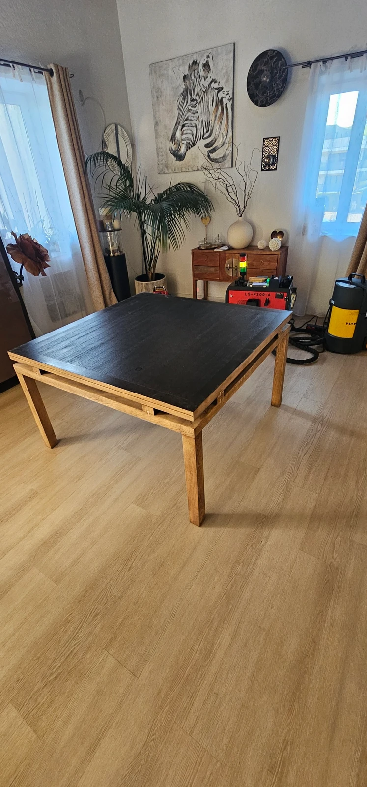 Table en cours de décapage : plateau encore foncé, ceinture et pieds déjà éclaircis.